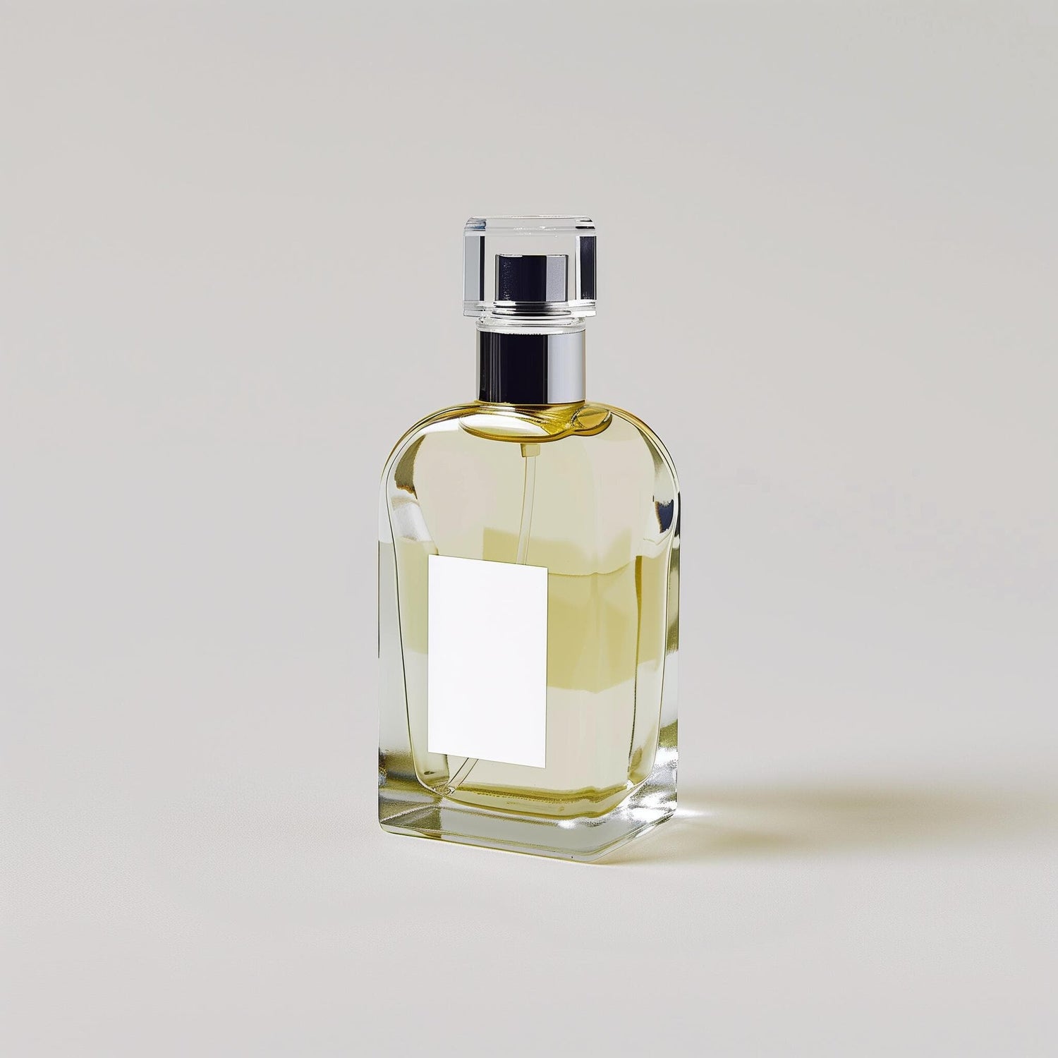 Pale yellow perfume bottle with a plain white label on a neutral background